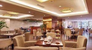 um restaurante com mesas e cadeiras em uma sala em Chengdu Sovereign Hotel em Chengdu
