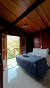 a large bed in a room with a large window at Casa Mar A Vista in Ilhabela