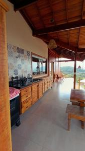 a large kitchen with wooden cabinets and a table and benches at Casa Mar A Vista in Ilhabela +64 photos