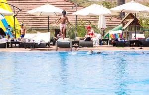 a group of people swimming in a swimming pool at Nordic Hotel Abuja in Abuja