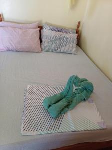 a bed with a pile of clothes on it at Calitang Pearl Lodge in El Nido +19 photos
