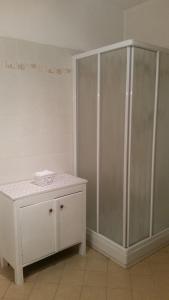 baño con ducha y armario blanco en Appartamento Valle dei Laghi, en Calavino
