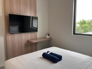 a bedroom with a bed with a tv on the wall at Hotel Cengkareng Inn in Jakarta