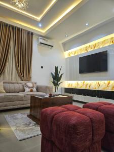 a living room with a couch and a flat screen tv at Mohills Apartment Wuye in Abuja