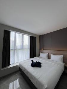 a bedroom with a large white bed with a black bag on it at Hotel Cengkareng Inn in Jakarta