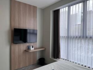 a bedroom with a flat screen tv and a window at Hotel Cengkareng Inn in Jakarta +8 photos