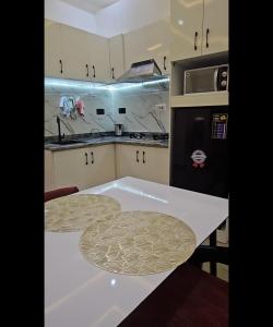 a kitchen with a white counter top and a refrigerator at Mohills Apartment Wuye in Abuja