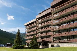 a tall building with trees in front of a mountain at Résidence Pierre & Vacances Inter-Résidences in Tignes