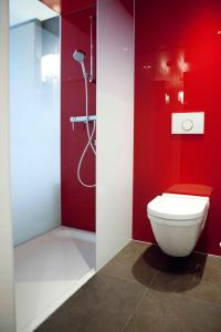 a red bathroom with a toilet and a shower at Agora Swiss Night by Fassbind in Lausanne