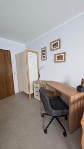 een kantoor met een houten bureau en een stoel bij Studio-Apartment Goslar in Wolfenbüttel