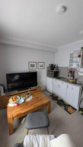a living room with a table and a kitchen at Studio-Apartment Goslar in Wolfenbüttel +2 photos
