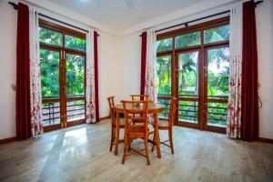Lakeside Villa : غرفة طعام مع طاولة وكراسي ونوافذ كبيرة