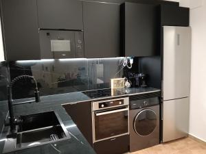 una cocina con estufa y refrigerador en Can Masia, en Olivella