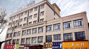 a large white building with windows on a street at VX Kaifeng Jinming Avenue Songcheng Road Hotel in Kaifeng