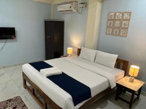um quarto com uma cama grande com duas luzes em Aqua Wave by YogiTree Hotels em North goa
