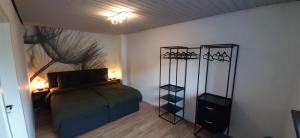 una camera da letto con un letto e due appendiabiti di Primslodge a Nalbach