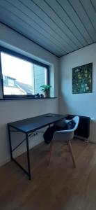 una stanza con un tavolo e un gatto sdraiato su una sedia di Primslodge a Nalbach