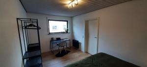 una camera da letto con un letto, una scrivania e una finestra di Primslodge a Nalbach