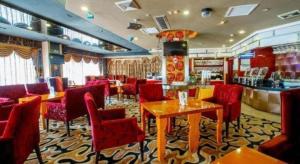 a restaurant with red chairs and tables and a bar at Zhongshan Louis Hotel in Zhongshan