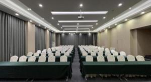 a conference room with white chairs and a screen at Jinjiang Inn Xi'an Zhonglou North Street Metro Station in Xi'an