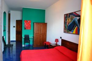 a bedroom with a red bed and a green wall at Bed & Breakfast Maredomus in Milazzo