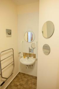 a bathroom with a sink and two mirrors at Glenernan Self Catering Cottages in Ballater