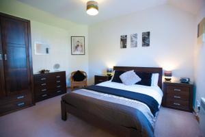 een slaapkamer met een groot bed en houten meubilair bij Glenernan Self Catering Cottages in Ballater