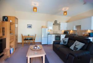 een woonkamer met een bank en een tafel bij Glenernan Self Catering Cottages in Ballater