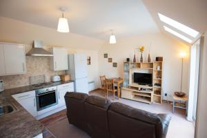 un soggiorno con divano e cucina di Glenernan Self Catering Cottages a Ballater Altre 4 foto