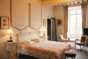 a bedroom with a bed and a table and chairs at Château Du Bois Glaume in Poligné