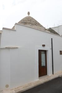Biały budynek z brązowymi drzwiami w obiekcie Trullo Dimora di Giorgia w Alberobello