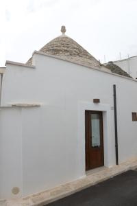 アルベロベッロにあるTrullo Dimora di Giorgiaの茶色の扉が付いた白い建物