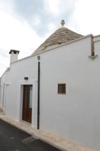 un edificio bianco con una porta marrone di Trullo Dimora di Giorgia ad Alberobello