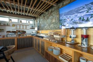 a restaurant with a counter with a large screen at Alexandros Mykonos in Klouvas