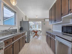 MatarangiCoastal Nook - Matarangi Holiday Home的厨房配有木制橱柜和桌子。