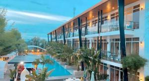 a large building with a swimming pool and palm trees at The Hotel Sophia in Cauayan