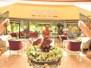 Camp WilhelmQueen Margarette Hotel的大厅里有雕像和桌椅