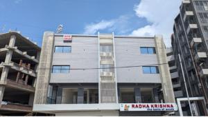 a gray building with a sign in front of it at Hotel JDS in Vapi