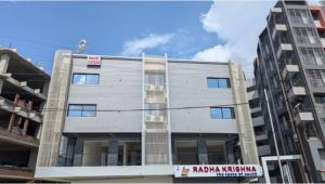 a gray building with a sign on the side of it at Hotel JDS in Vapi