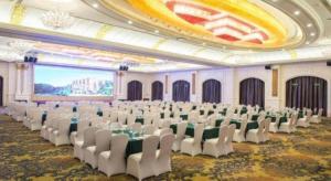 a large banquet hall with white chairs and a large screen at Country Garden Phoenix Hotel Xinhui Jiangmen in Xinhui +179 photos