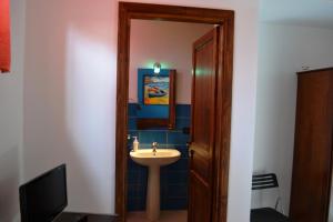 a bathroom with a sink and a mirror and a television at Bed & Breakfast Maredomus in Milazzo +59 photos