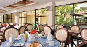PeteronganYusro Hotel Restaurant & Convention的餐厅里有桌椅和窗户。