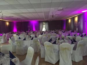 una sala per banchetti con tavoli bianchi e sedie bianche di Abbey Hotel a Ballyvourney