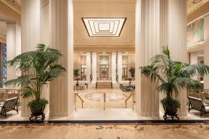 a lobby with two palm trees in a building at Waldorf Astoria New York in New York