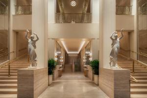 a hallway with two statues of women in a building at Waldorf Astoria New York in New York