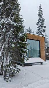 ein Gebäude im Schnee neben einigen Bäumen in der Unterkunft Lapland Winter Park Chalets in Rovaniemi