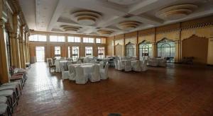 una grande stanza con tavoli e sedie bianchi di Grand Norling Hotel's Resort a Baudhatinchule Altre 78 foto