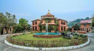 un grande edificio con una fontana di fronte di Grand Norling Hotel's Resort a Baudhatinchule