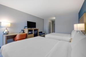 a hotel room with two beds and a tv at Comfort Inn & Suites Alexandria West in Alexandria