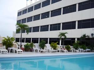a hotel swimming pool with chairs and a building at Casa Boutique Hotel in Phnom Penh